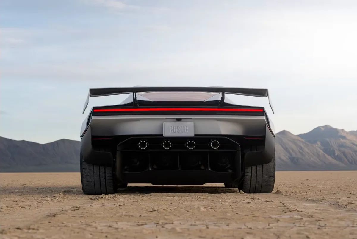 Traseira do novo Tesla Roadster com asa aerodinâmica e lanterna contínua em leito seco de deserto